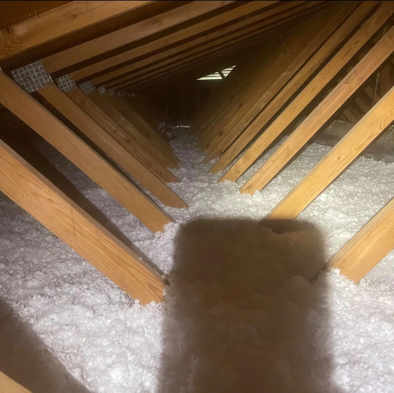 Attic ventilation and insulation setup featuring gable vents, exhaust vents, and bathroom fans for improved indoor air quality, natural ventilation, and prevention of mold growth after ventilation installation for roof ventilation. 